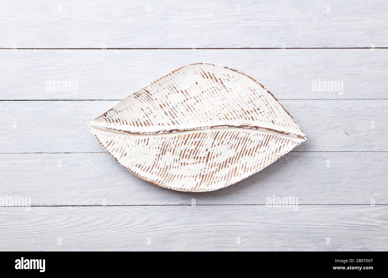 Wooden leaf shaped tray on grey background. Top view. Copy space Stock