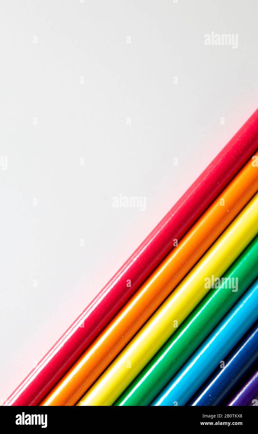 Colored pencils arranged in diagonal pattern on white background Stock Photo