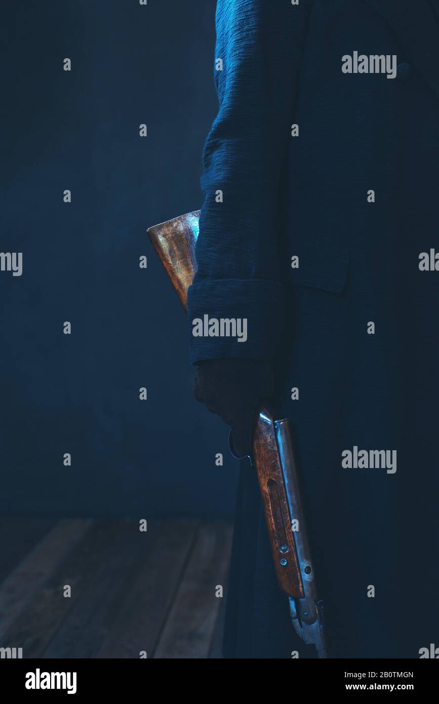 Man in long black coat holding rifle Stock Photo Alamy