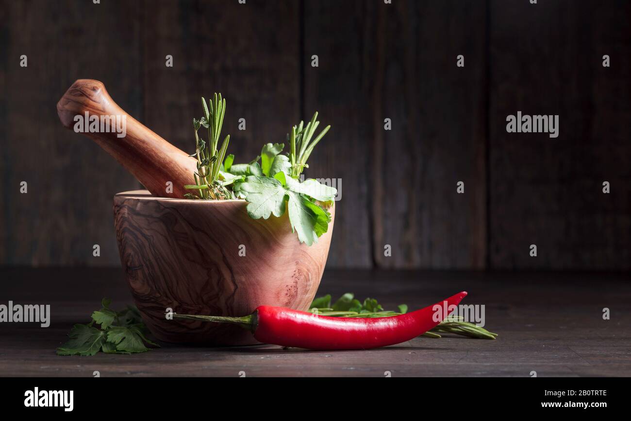 Red pepper and various aromatic herbs on a old wooden table Stock Photo ...