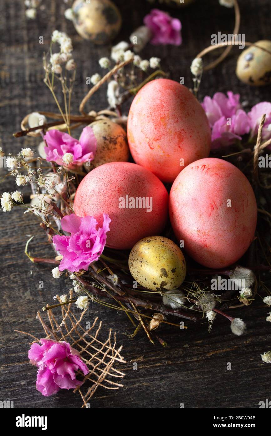 Easter eggs close-up on wooden background. Pink  handmade easter eggs in a basket. Stock Photo