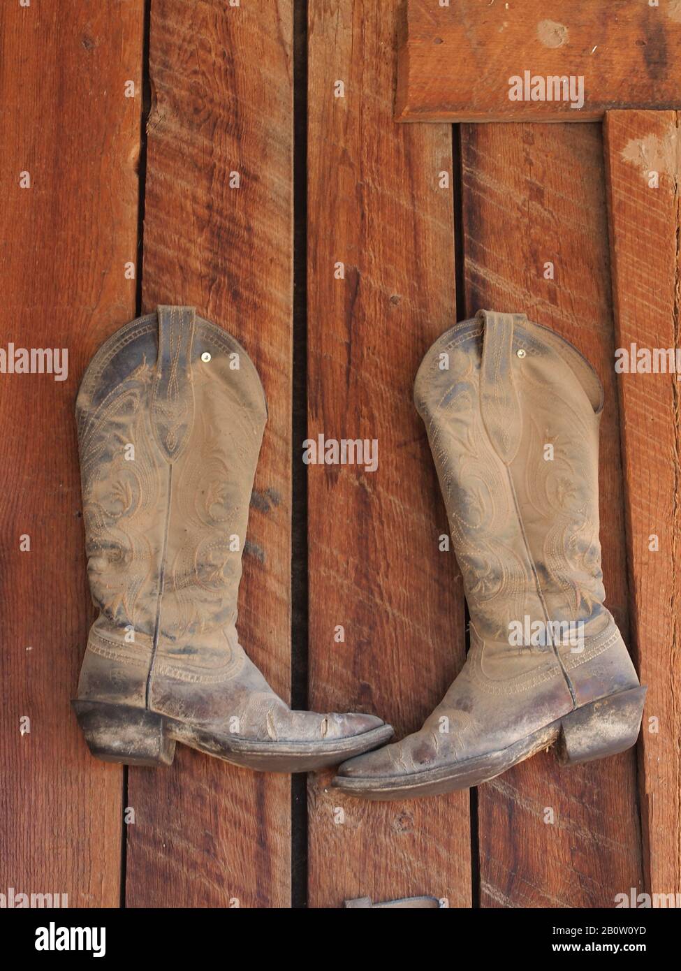 Traditional western wear and equipment hanging on an Arizona barn. Boots  and stir ups define the old west Stock Photo - Alamy