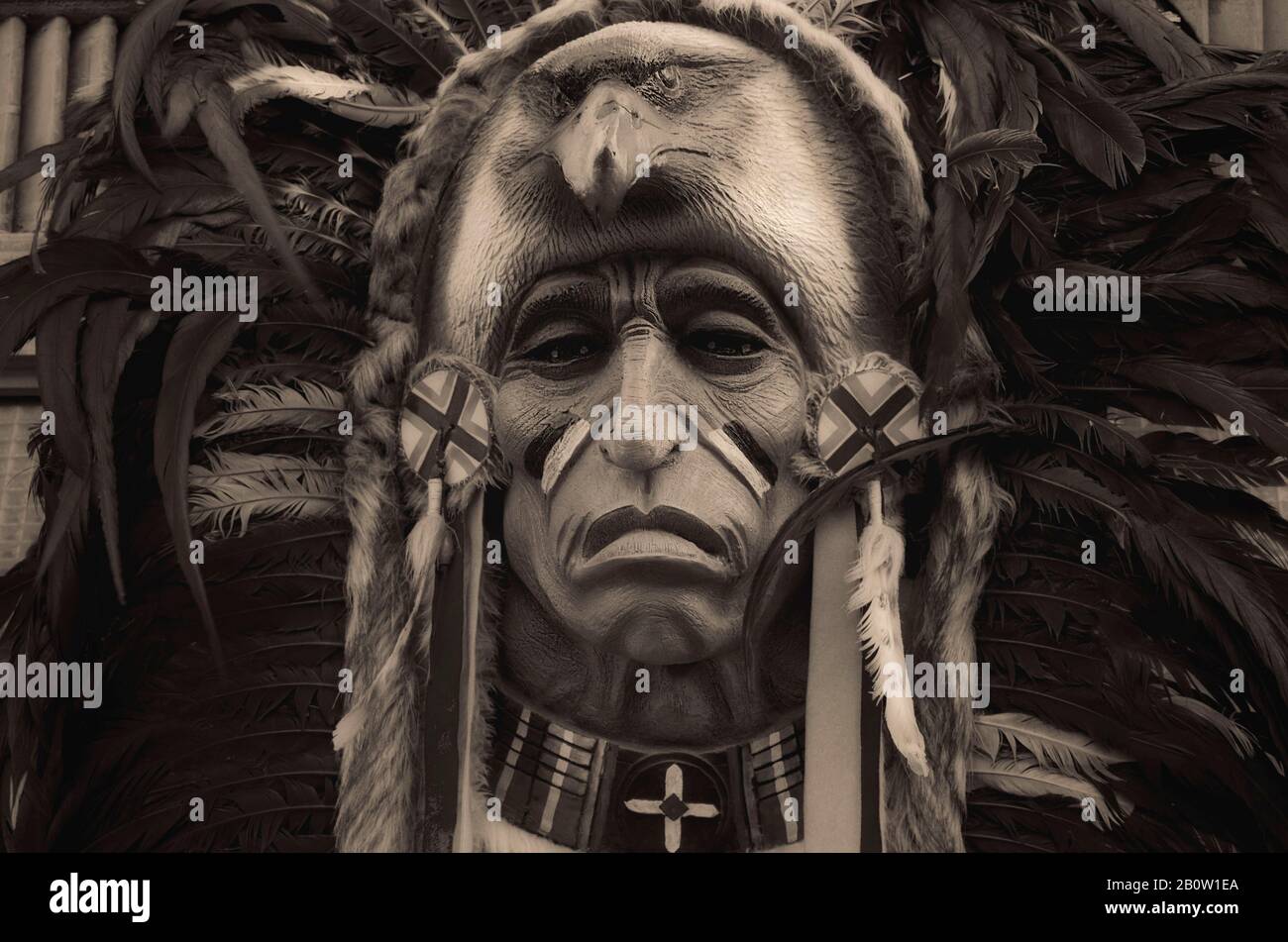 wood carving of an ancient feather black and white mask Stock Photo