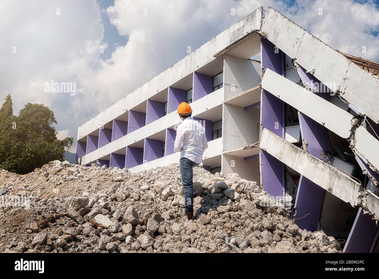 Engineer holding tablet is checking for destruction, demolishing building. Stock Photo