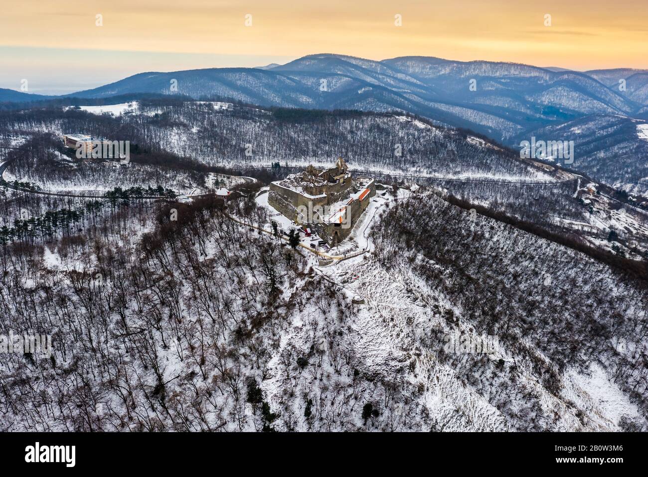Visegrad, Hungary - Aerial panoramic view of the beautiful old and snowy high castle of Visegrad at sunrise on a winter morning with the hills of Pili Stock Photo