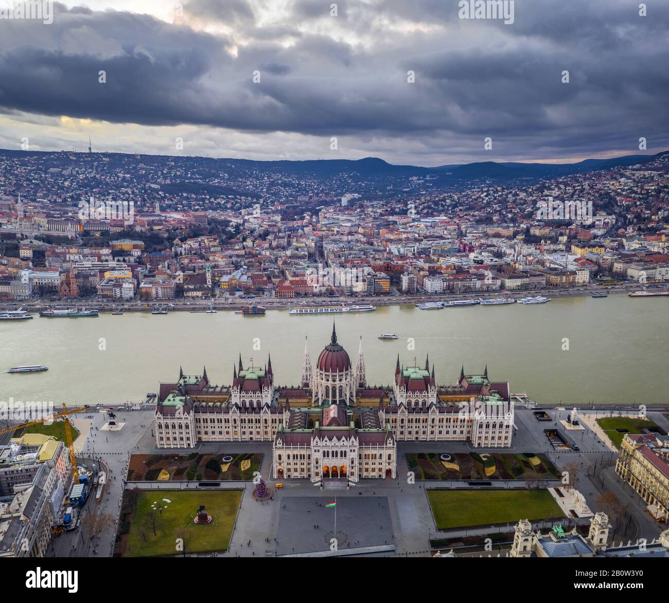 Budapest, Hungary - Aerial view of the Hungarian Parliament building at sunset with Christmas tree and Buda Hills at background Stock Photo