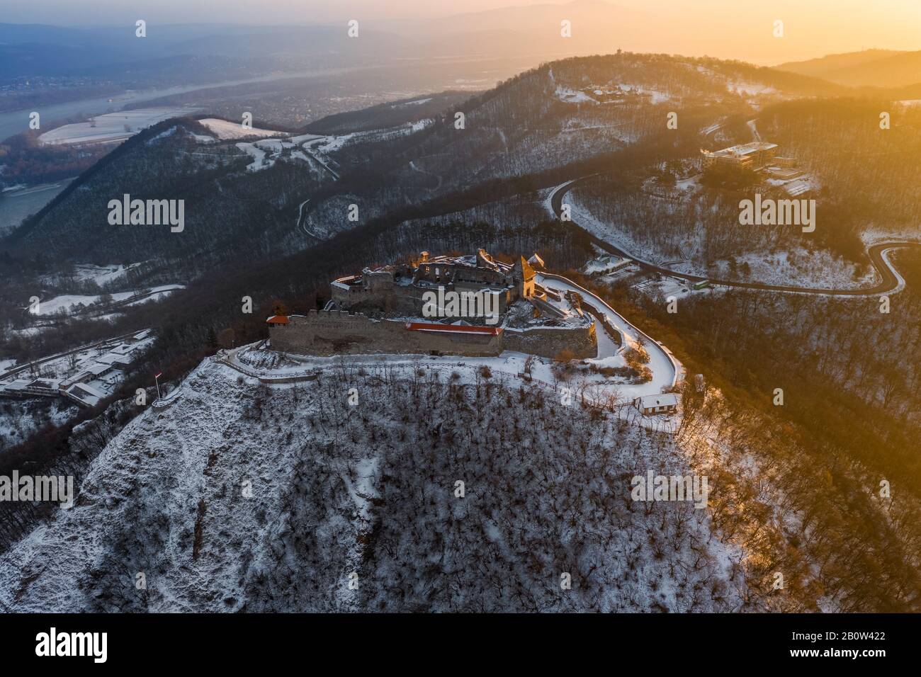 Visegrad, Hungary - Aerial panoramic view of the beautiful old and snowy high castle of Visegrad at sunrise on a winter morning with the hills of Pili Stock Photo