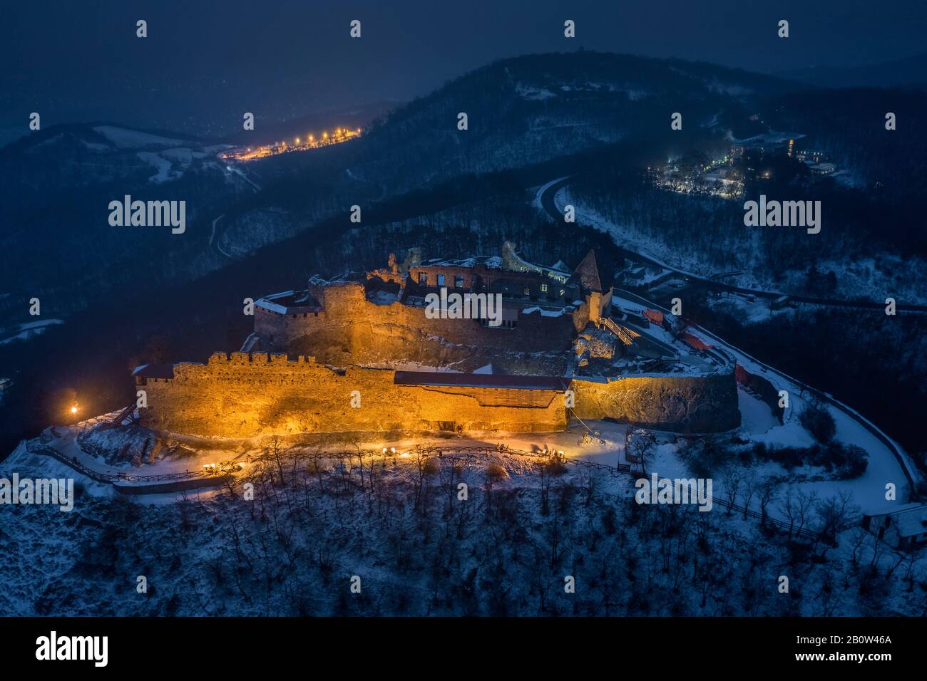 Visegrad, Hungary - Aerial view of the beautiful, illuminated high castle of Visegrad at blue hour with snowy hills of Pilis on a winter night Stock Photo