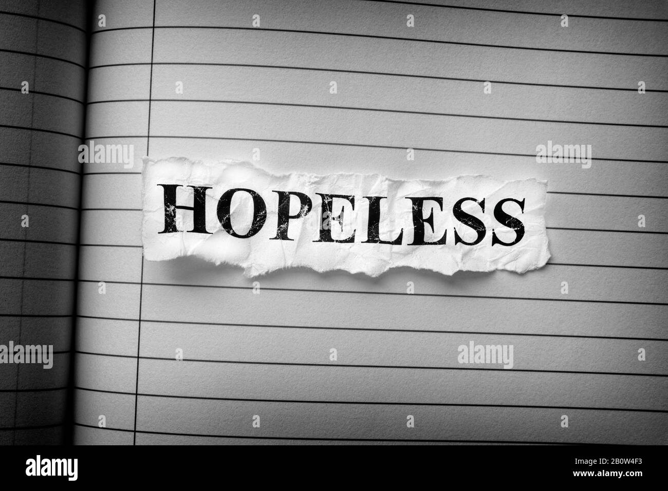 Crumpled piece of paper with the word Hopeless. Black and White. Close up. Stock Photo