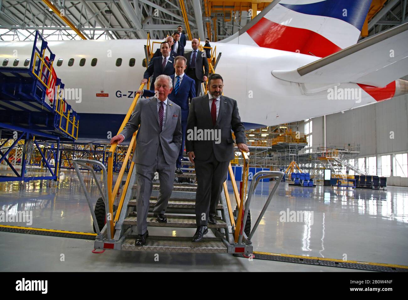 The Prince of Wales and British Airways CEO Alex Cruz walk down the steps after being shown around a Boeing 787-9 Dreamliner during a visit to the British Airways Maintenance Centre at Cardiff Airport, Wales, celebrating the company's 100th anniversary. Stock Photo