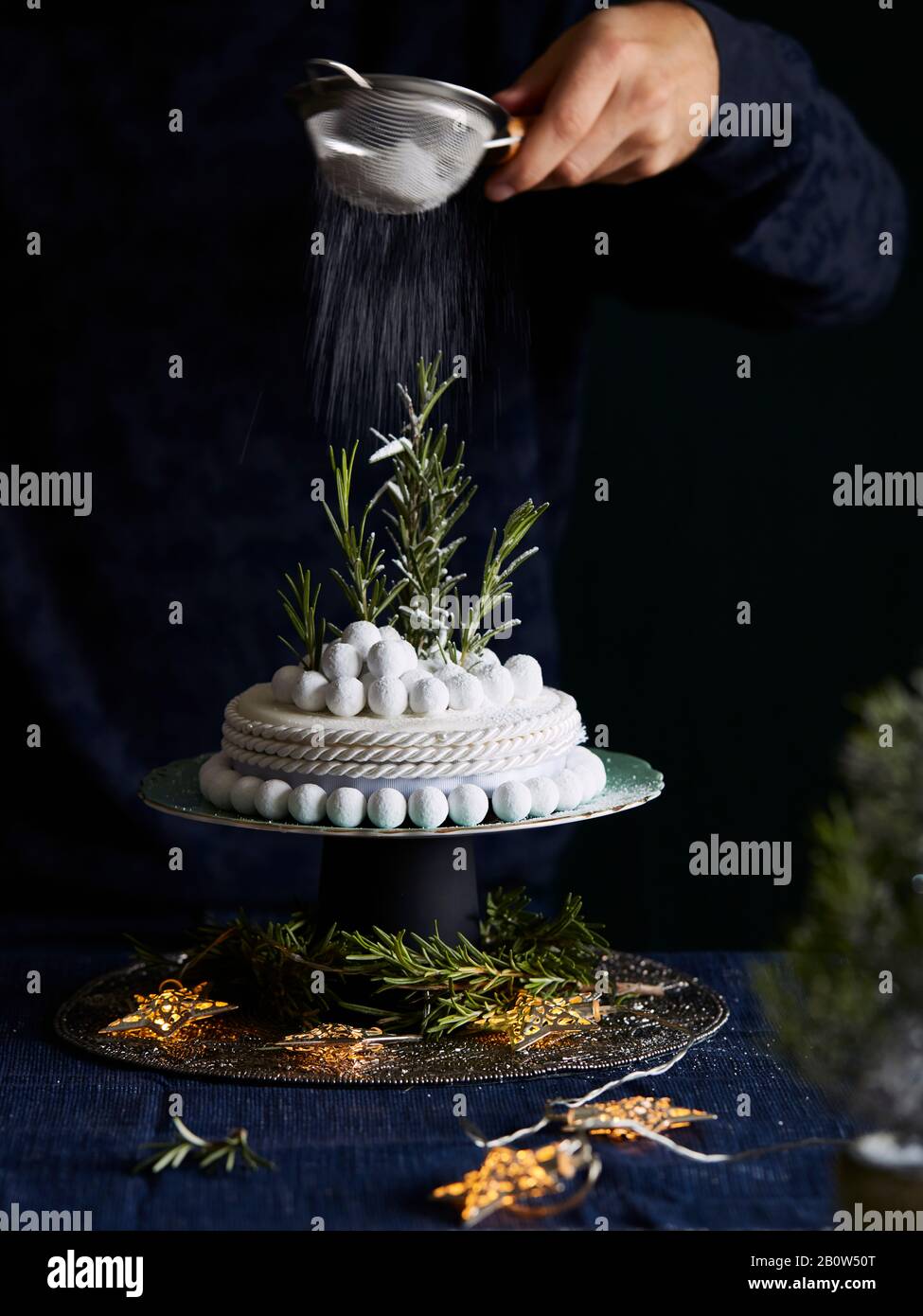Close up of richly decorated Halloween cake with white icing and rosemary sprigs. Stock Photo