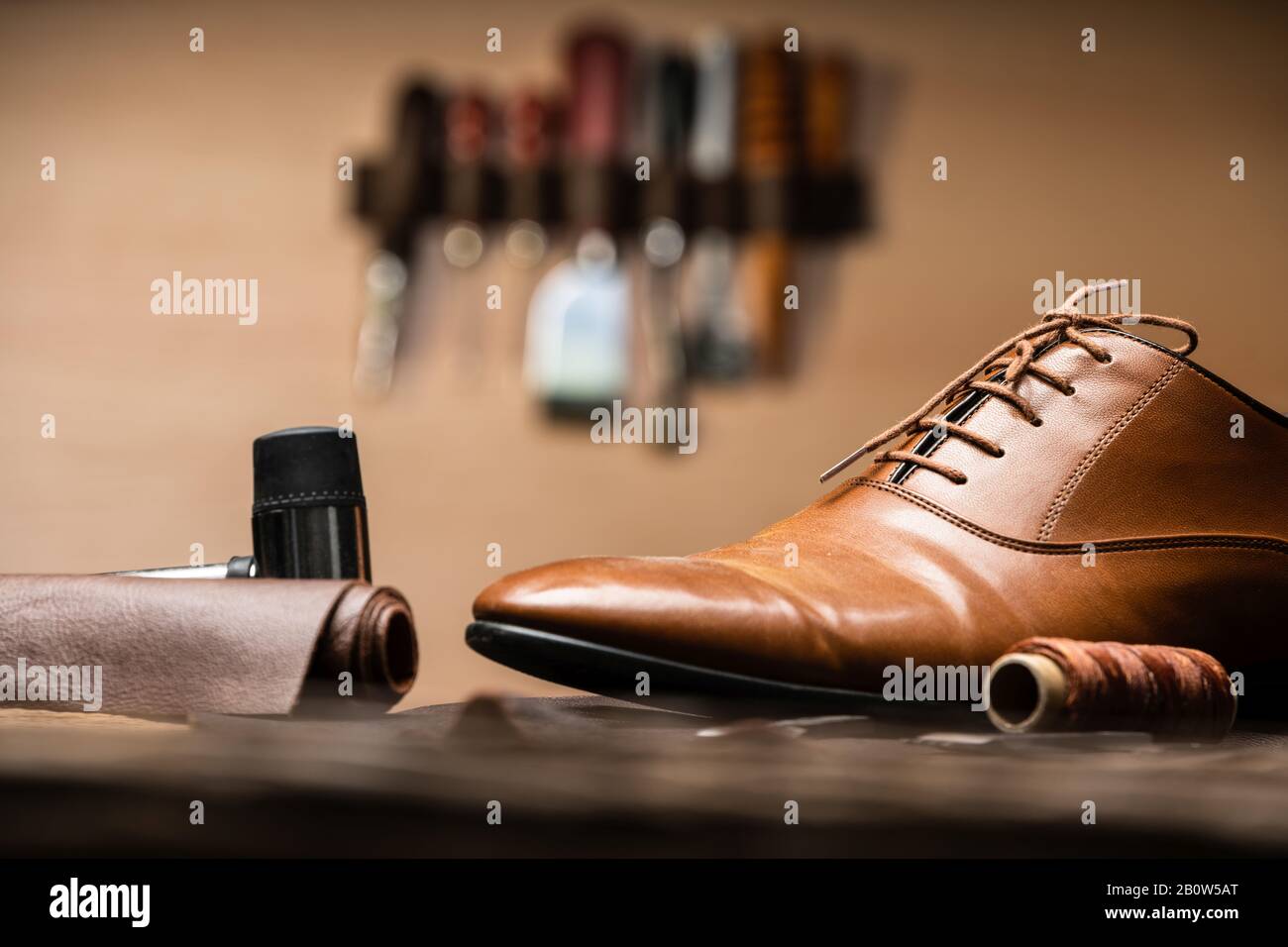 Shoemaker Tools And Finished Shoe On Desk Stock Photo