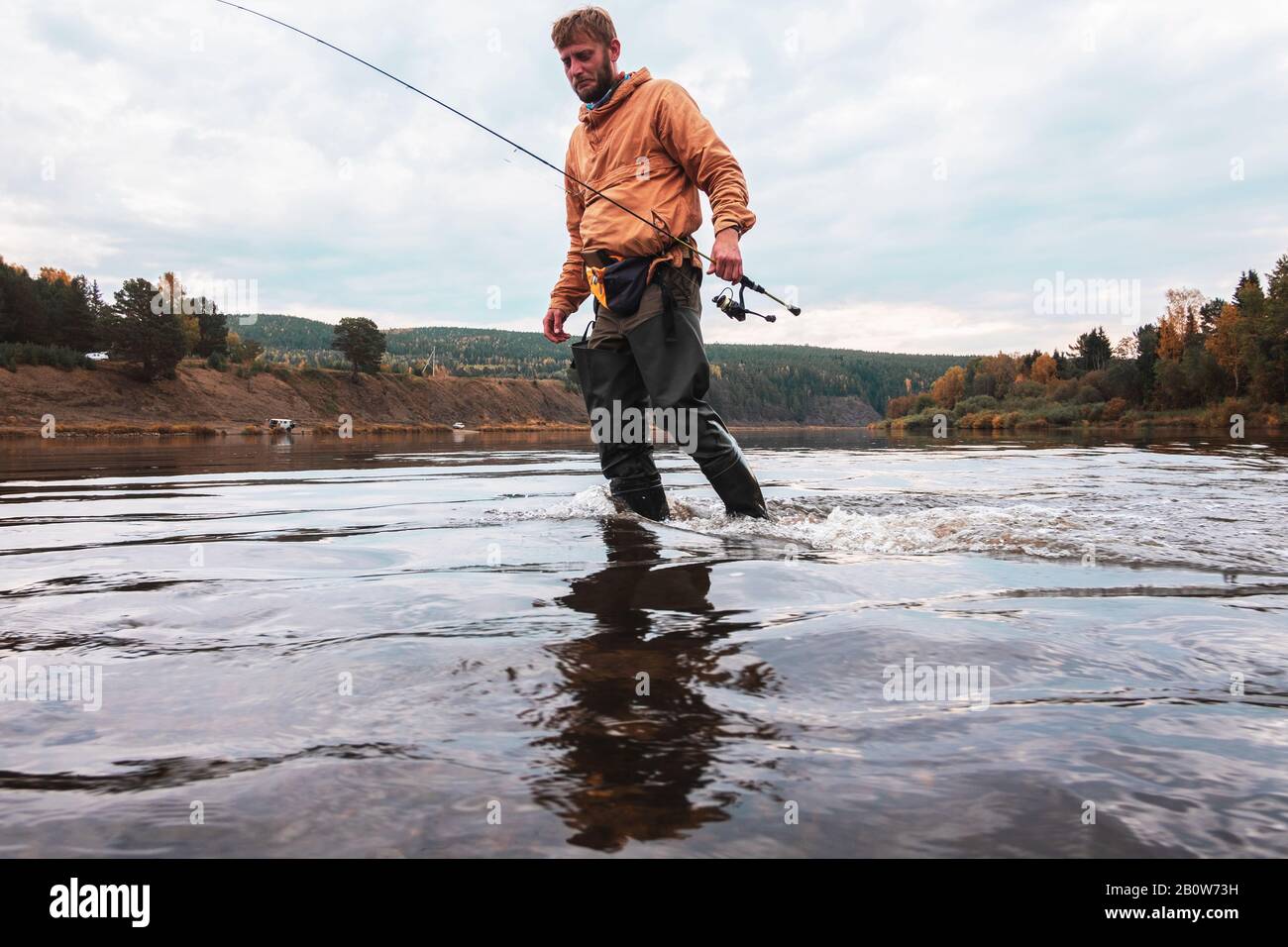 Angler in middle of lake in autumn, Russia Stock Photo