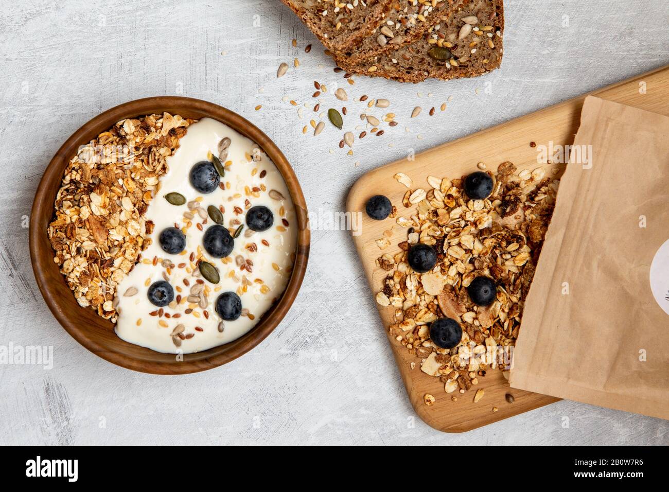 Bowl of muesli and blueberries on yogurt, multi-seed bread Stock Photo