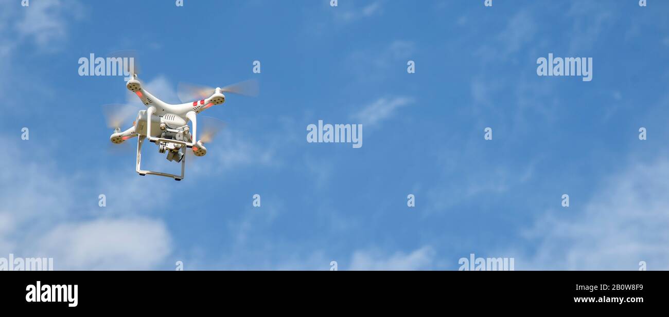 Drone with digital camera flying in the sky. Modern technology for aerial video and photography. Stock Photo