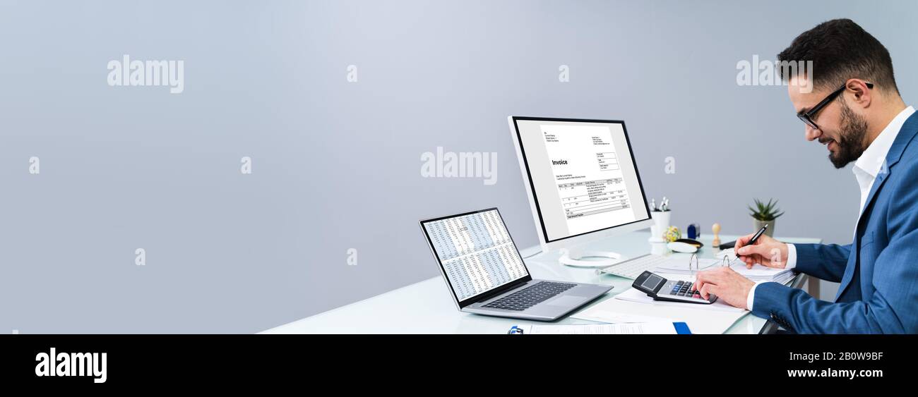 Accountant Making Invoice On Computer At Desk Stock Photo - Alamy