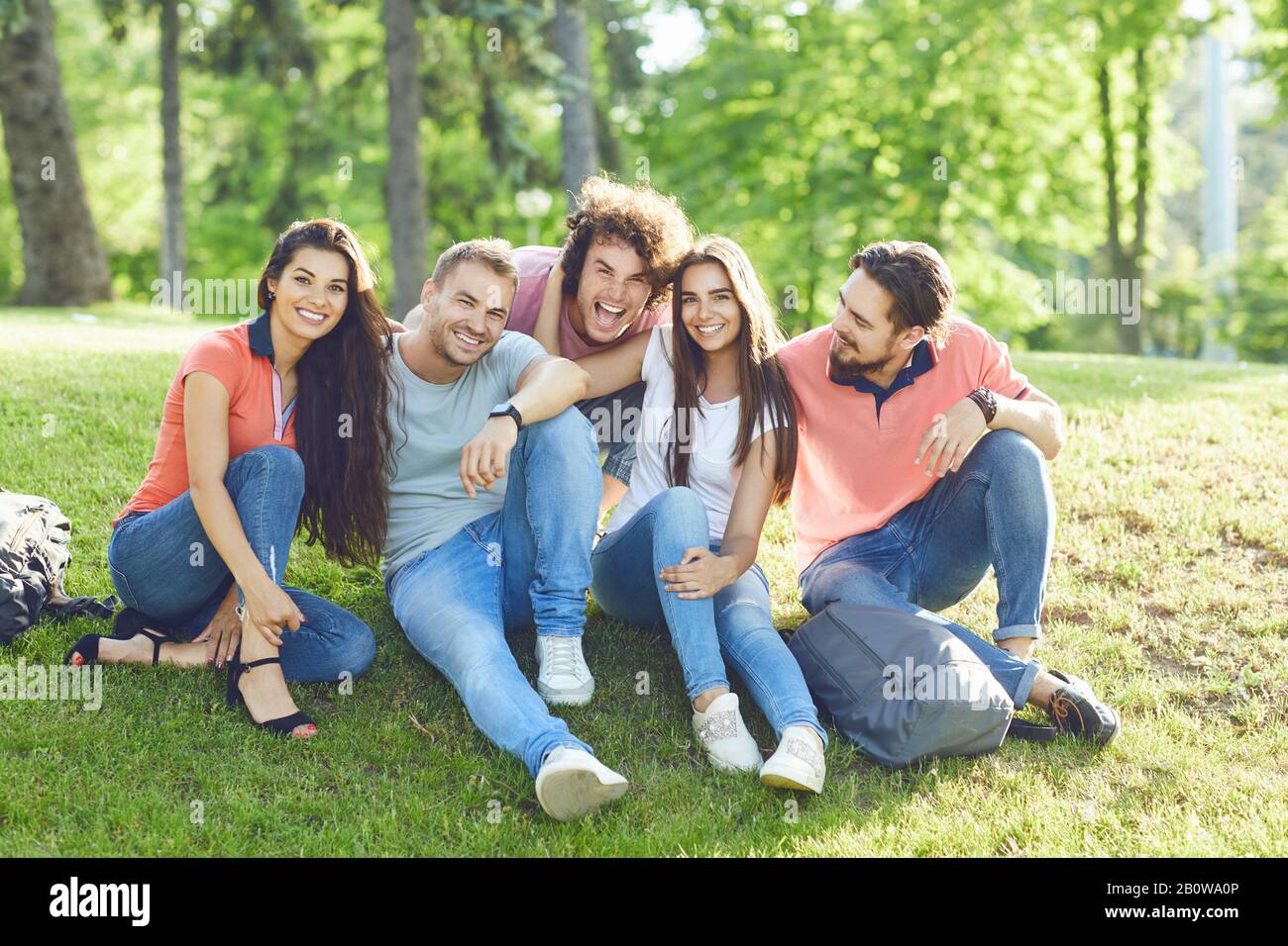 Friends fun sitting on the grass in a city park Stock Photo