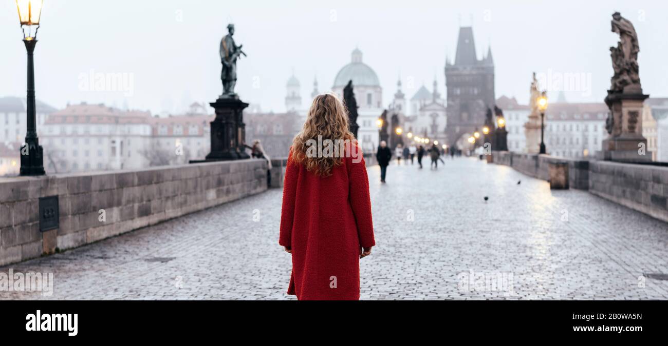 Female tourist walking alone on the Charles Bridge during the early morning in Prague, capital of Czech Republic Stock Photo