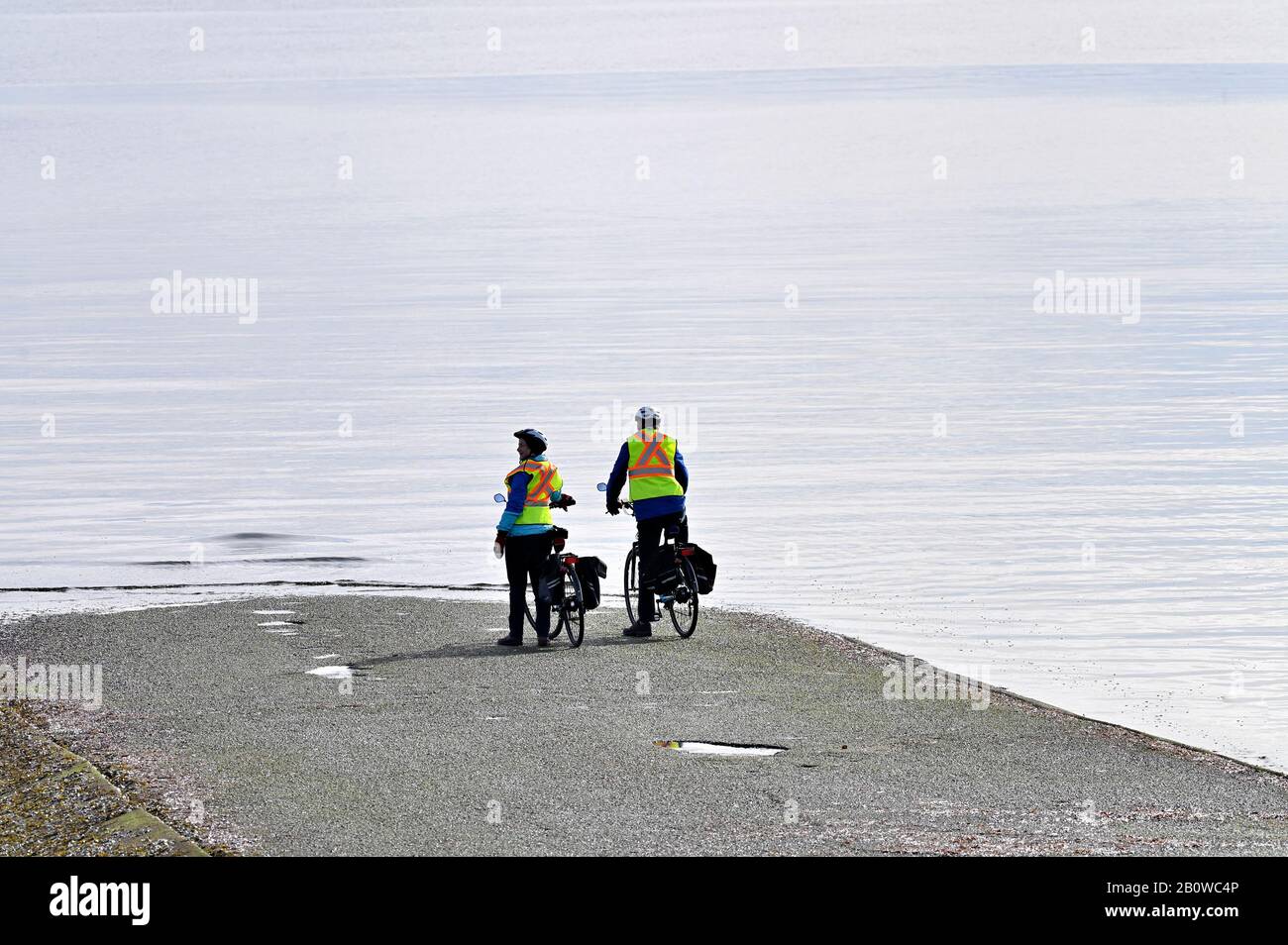 Two cyclists on a boat ramp. Stock Photo