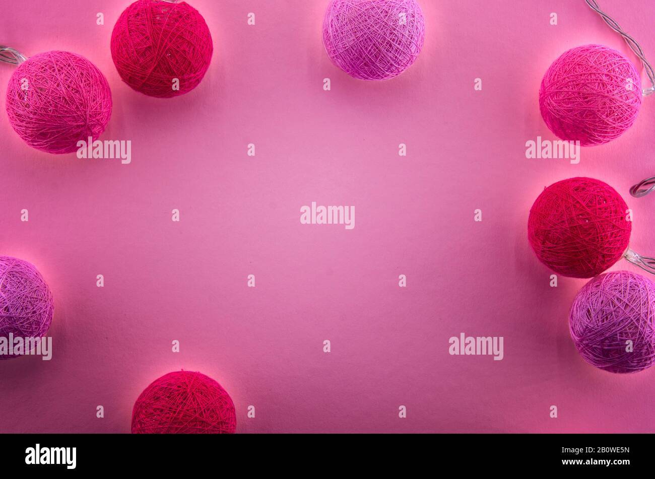 Pink background with garland of pink and red balls made of threads or yarn.  Lighting cotton thread balls. Valentines Day, Women`s, Wedding, Mother`s  Stock Photo - Alamy