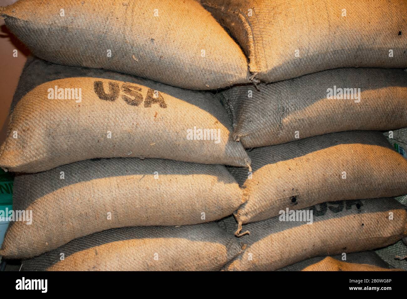 Stacked full bags of coffee closeup with USA stamped on some of them Stock Photo