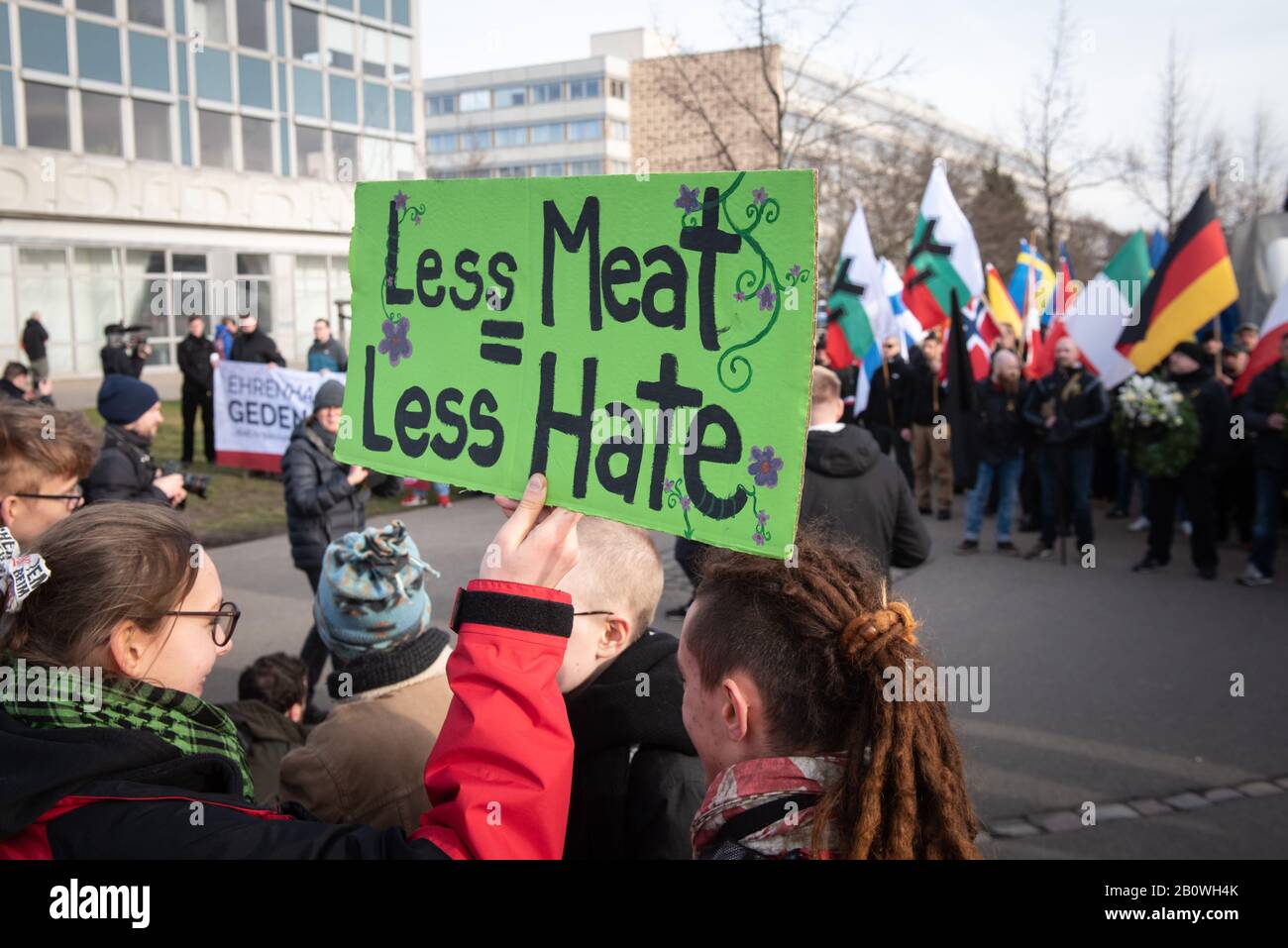 15th February 2020. Dresden, Saxony, Germany. Pictured:  An anti-fascist holds up a placard in front of the far-right groups. / Far-right groups conve Stock Photo