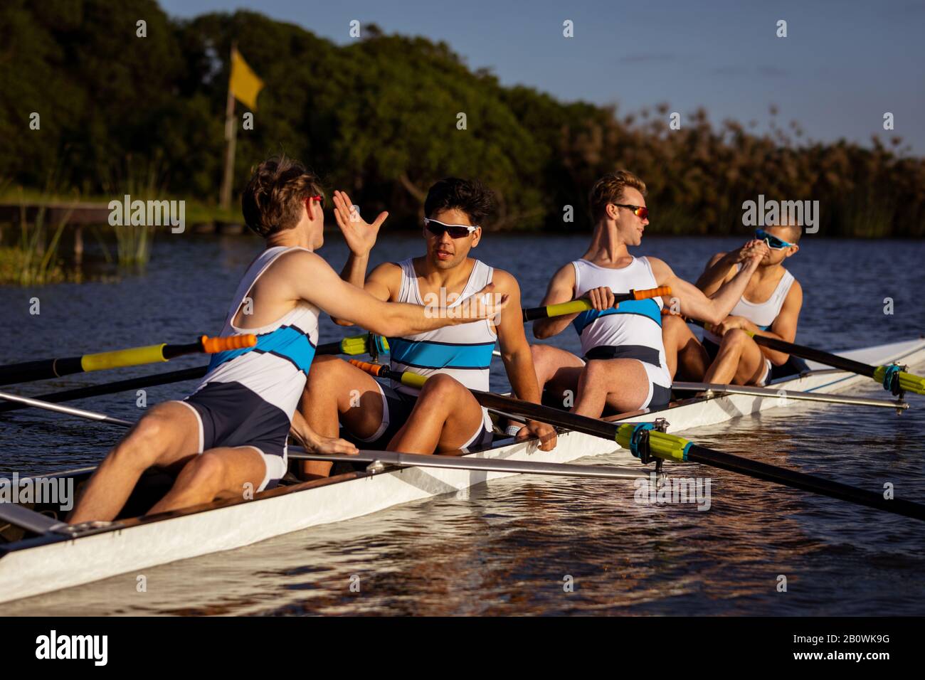 Teammates rowing on the water Stock Photo