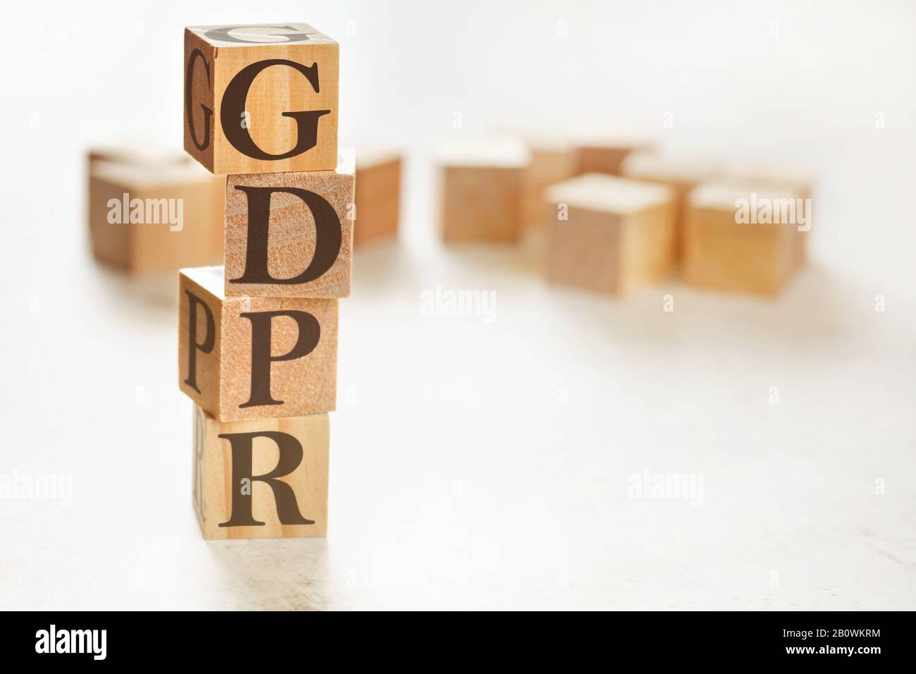 Four wooden cubes arranged in stack with letters GDPR meaning General Data Protection Regulation on them, space for text image at down right corner Stock Photo