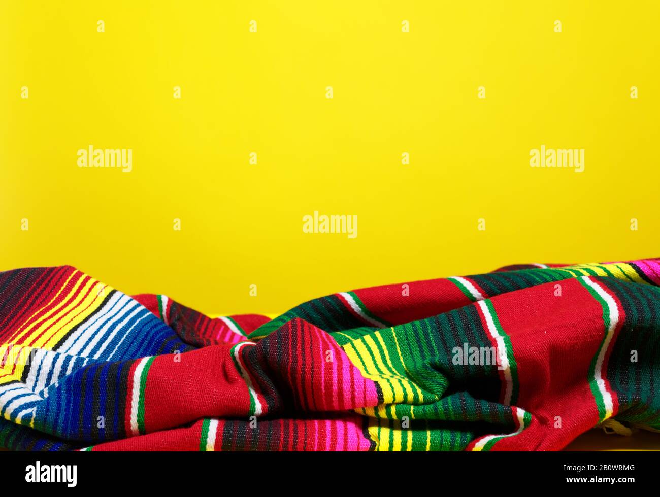 Colorful Mexican serape blanket on a yellow background Stock Photo