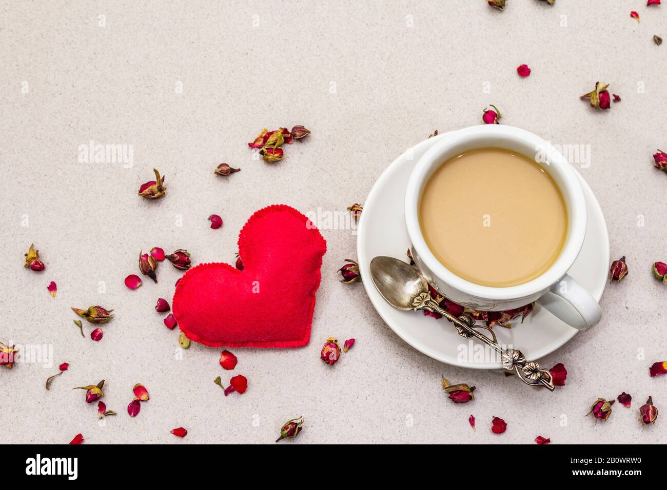 Good morning. Cup of coffee, rose buds and petals, red felt heart ...