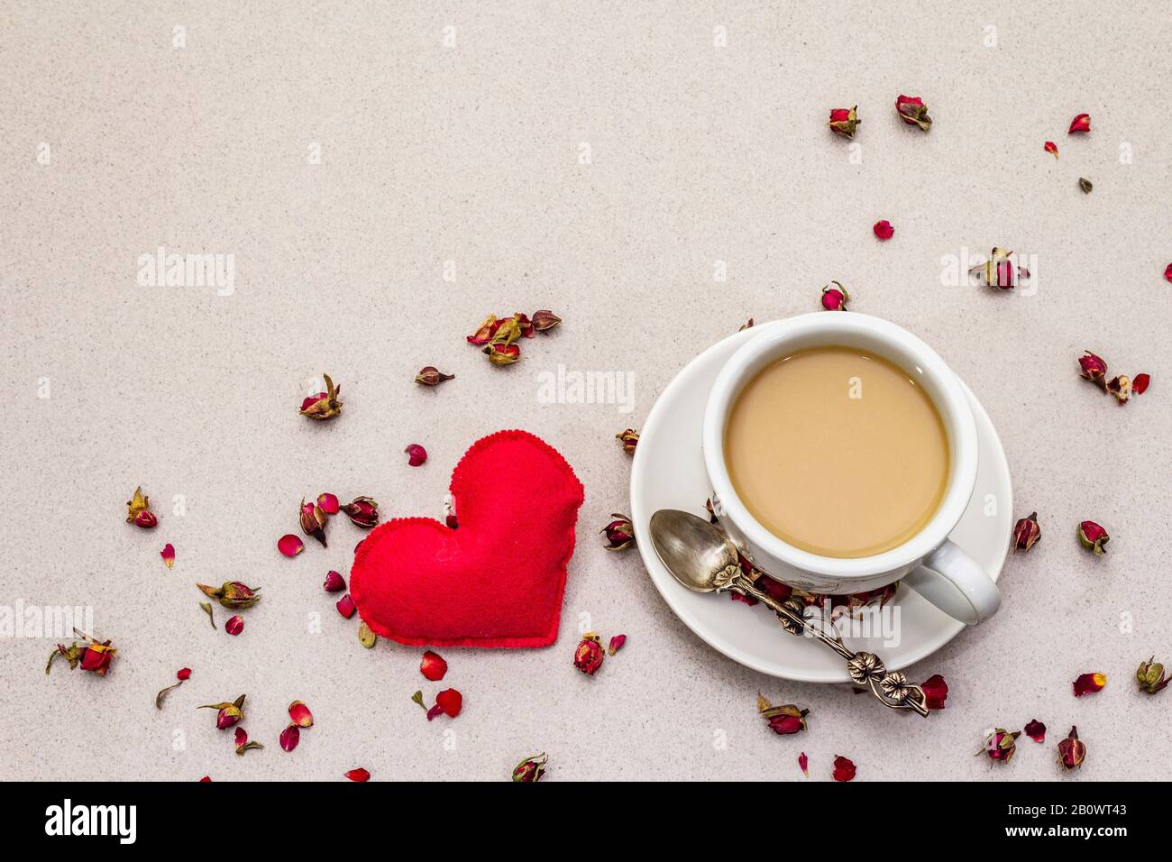 Good morning. Cup of coffee, rose buds and petals, red felt heart ...