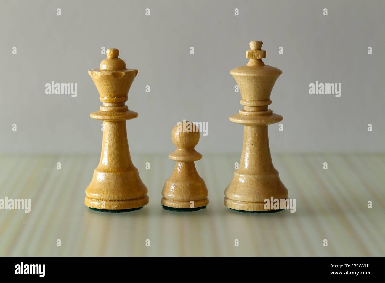 Family - White Queen, King and Pawn - Chess Pieces on a Blurry Brown Background Stock Photo