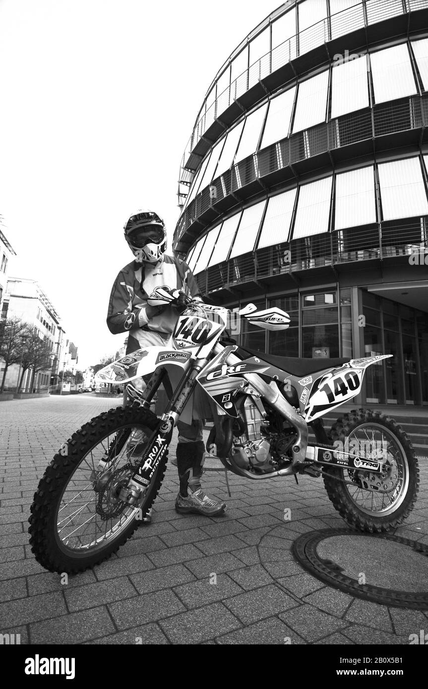Motorcyclist stands behind his motorcycle Stock Photo Alamy
