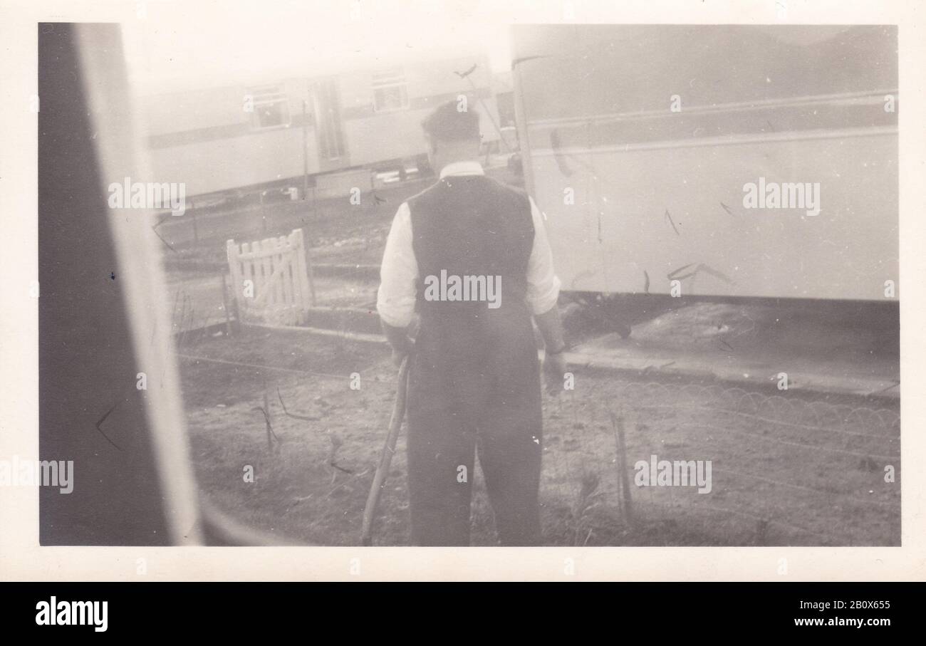 Vintage black and white photo of man at caravan site 1950s Stock Photo
