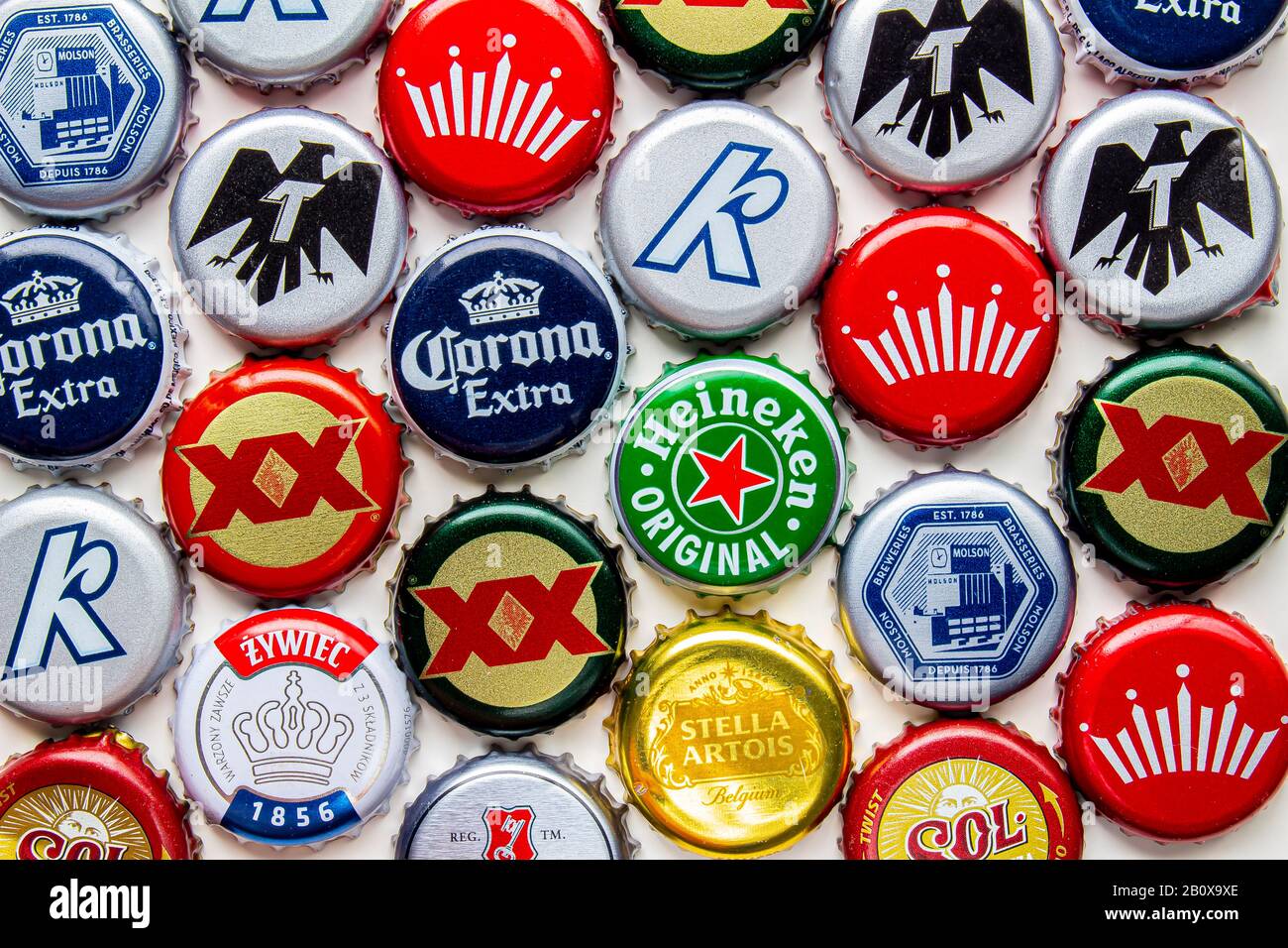 Calgary, Alberta, Canada. Feb 21 2020. Several beer bottle caps on a white background. Corona, Stella, Budweiser, DosEquis, Molson, Sol, Tecate, Kokan Stock Photo