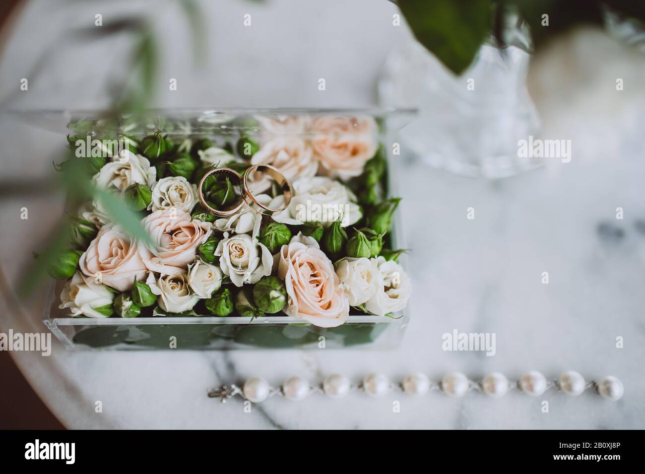 Wine glasses, wedding rings bedding of grass and moss on white table next  to bohemian tipi arch decorated in boho style with flowers and candles and  Stock Photo - Alamy