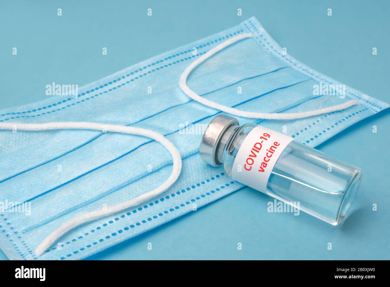 COVID-19. Vaccine from COVID-19. Blue medical disposable face mask with covid-19 print. Dangerous virus, bacteria. Epidemic over the world. Dangerous virus, bacteria. Biotechnology concept. Healthcare Stock Photo