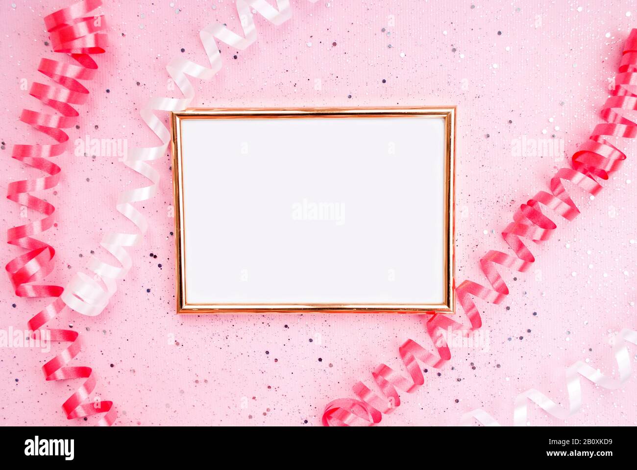 White serpentine, gold photo frame pink background with sparkles. Holiday, Anniversary, Birthday, Women's Day. Flat lat. Top view. Place for text Stock Photo