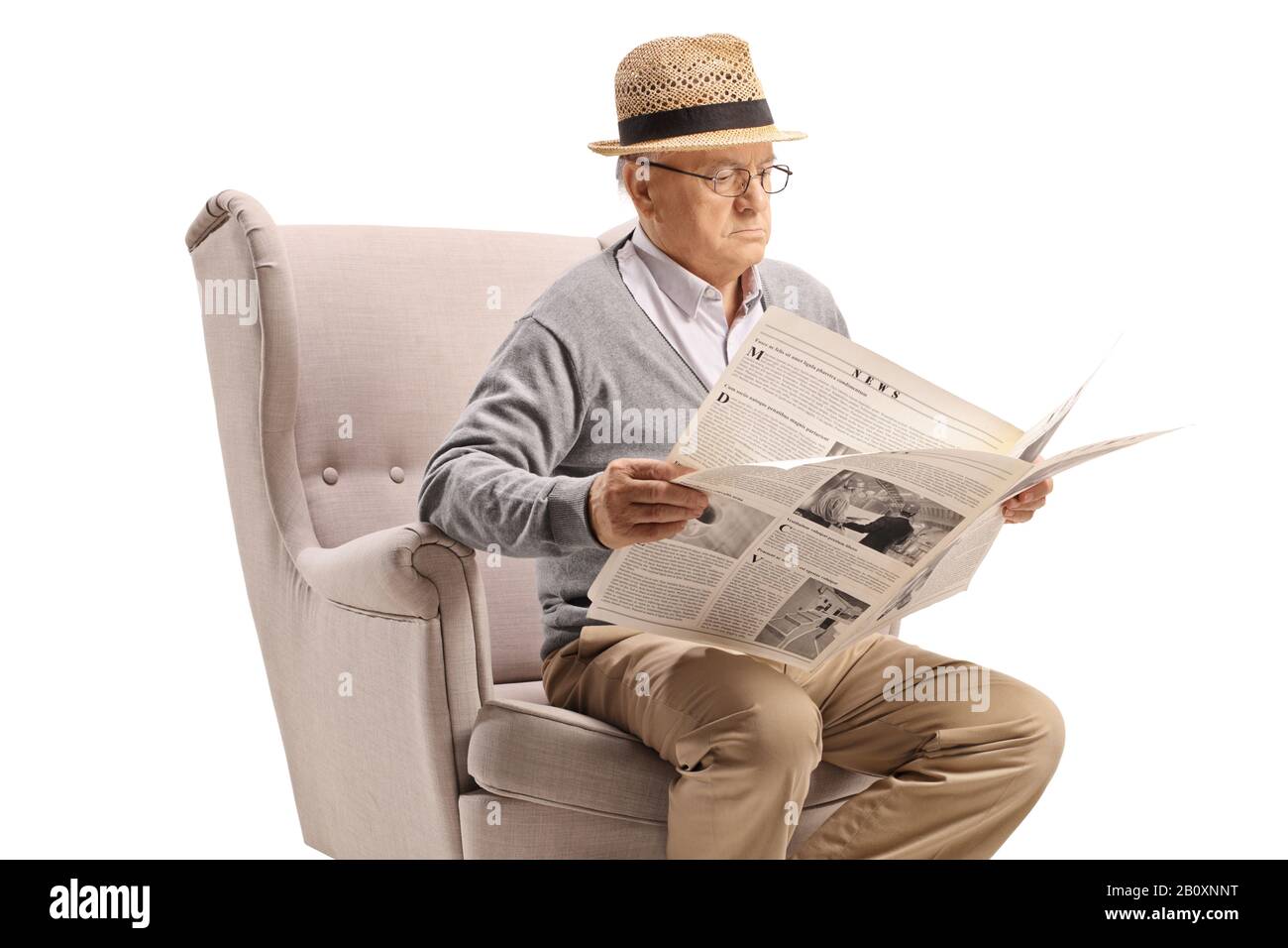 Senior man sitting in an armchair and reading a newspaper isolated on ...