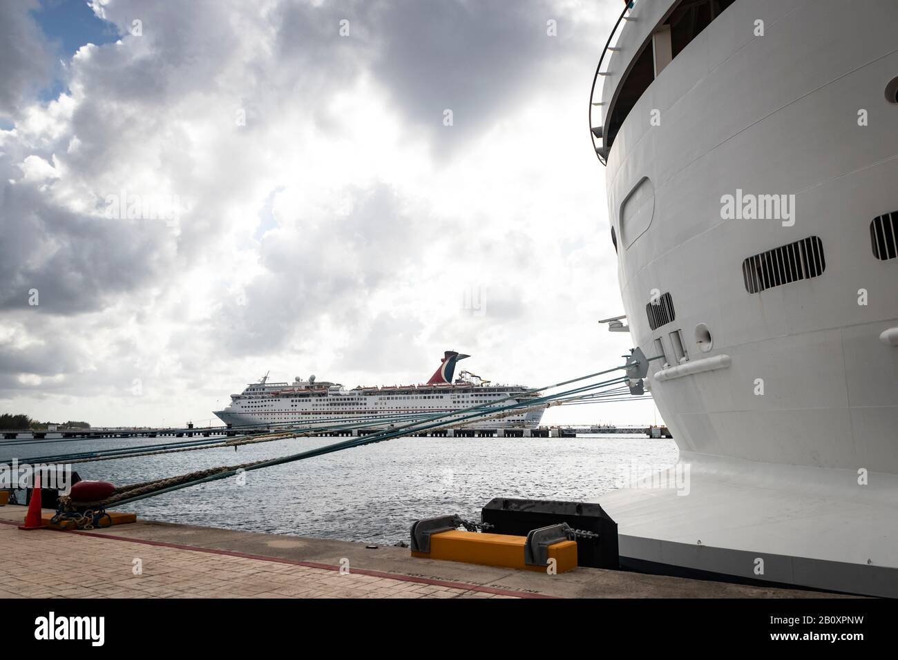 Distant view of 'Carnival Fantasy' cruise ship, at port in Cozumel under bright cloudy skies Stock Photo