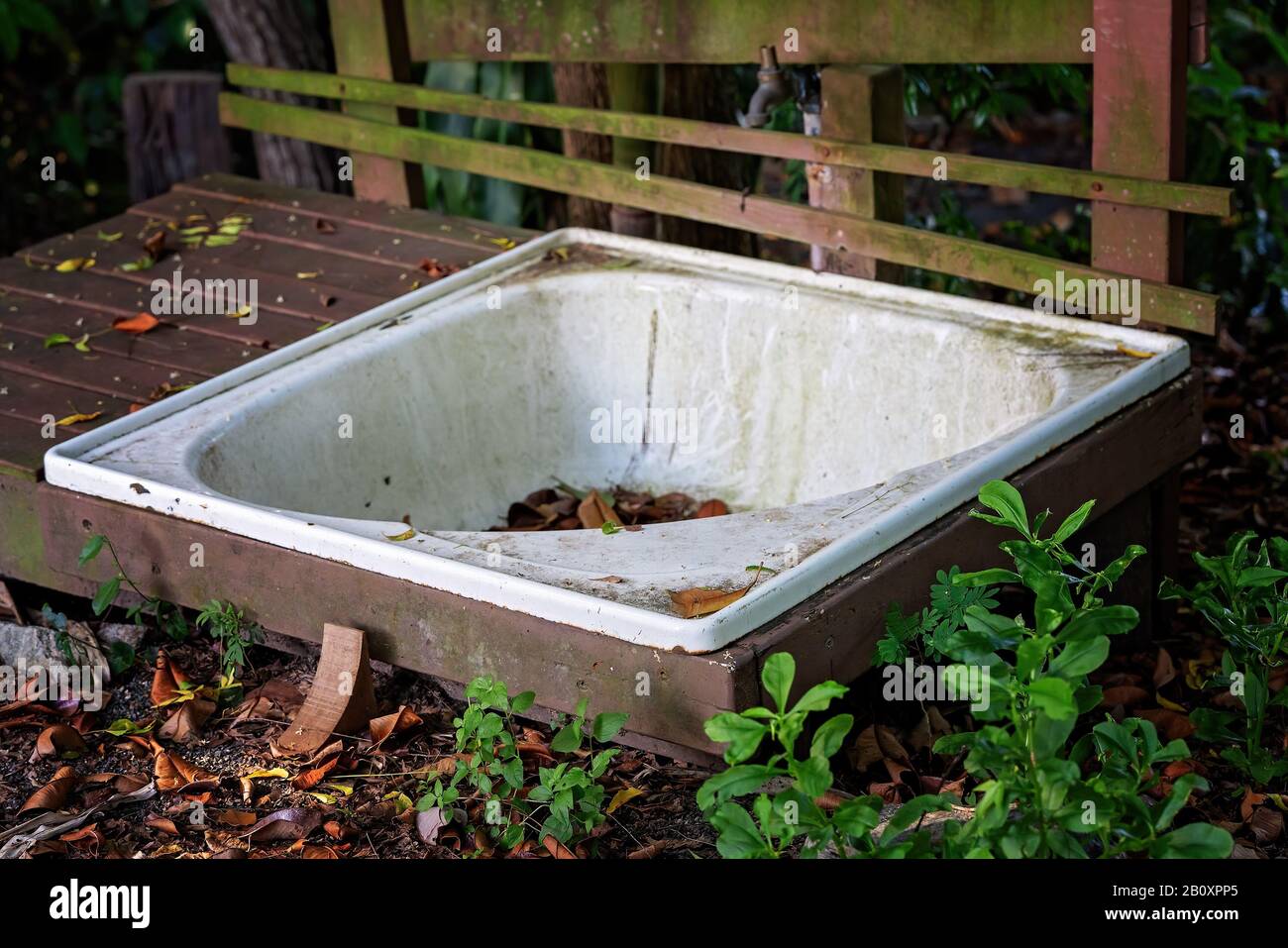 An old bathtub left abandoned and dirty in an outdoor garden