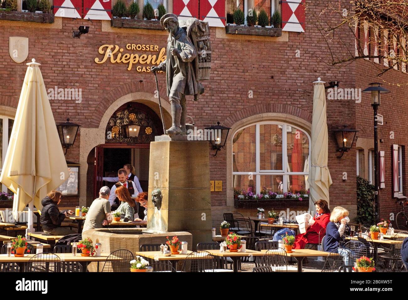 sidewalk restaurant and Kiepenkerl statue, Germany, North Rhine-Westphalia, Munster Stock Photo