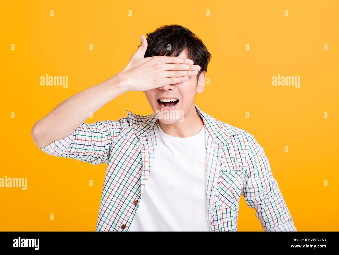 excited young man screaming and hand covering eyes Stock Photo - Alamy