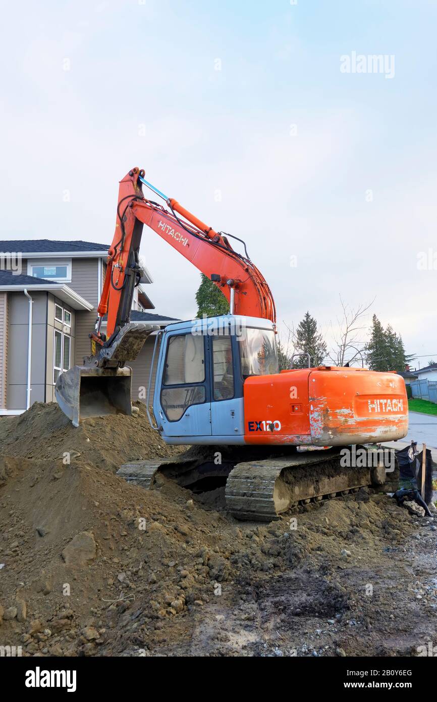A Hitachi backhoe sitting idle at a residential excavation site. Stock Photo