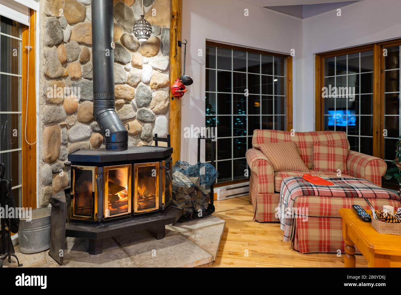 Wood stove fireplace with metal body and glass door in house with cozy  interior Stock Photo - Alamy