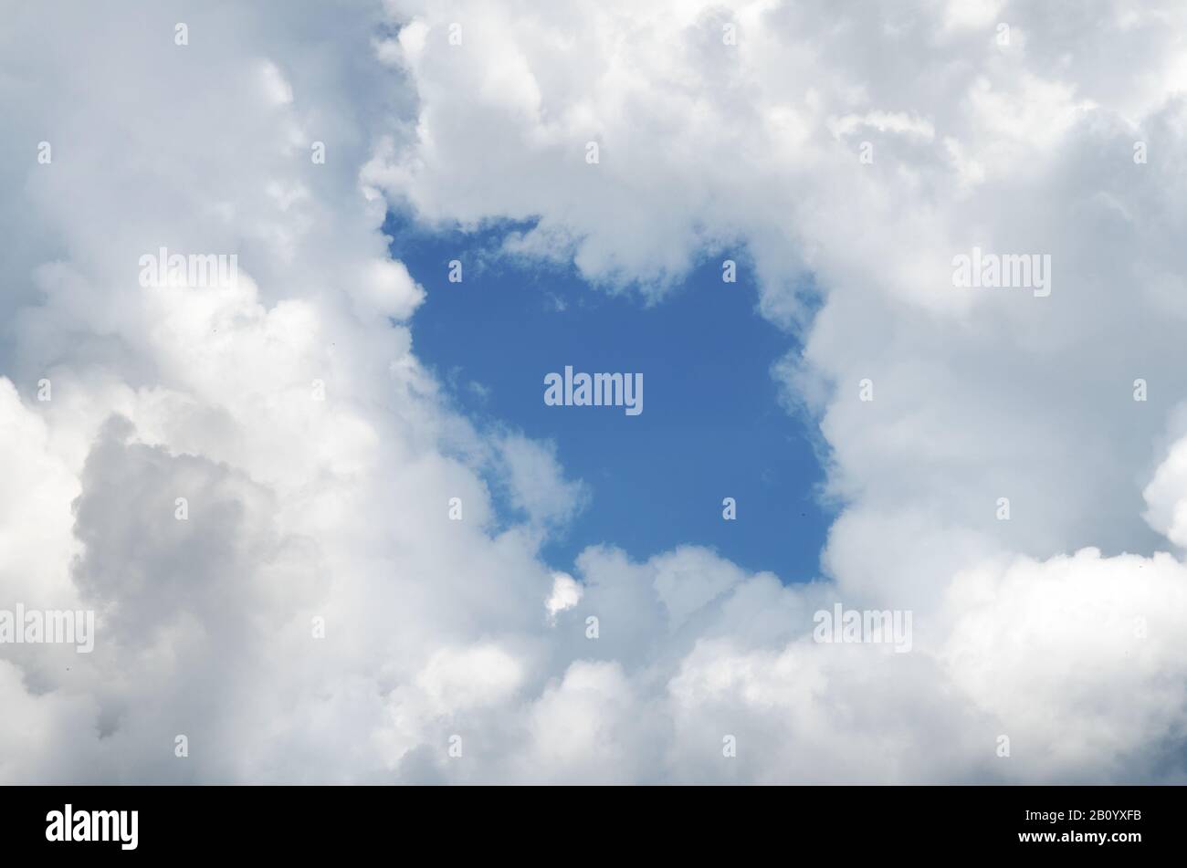 Hole in the clouds. Beautiful white clouds on blue sky with holes in