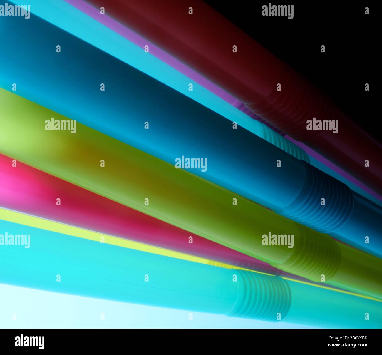Background from multi-colored plastic cocktail tubes on a dark background Stock Photo