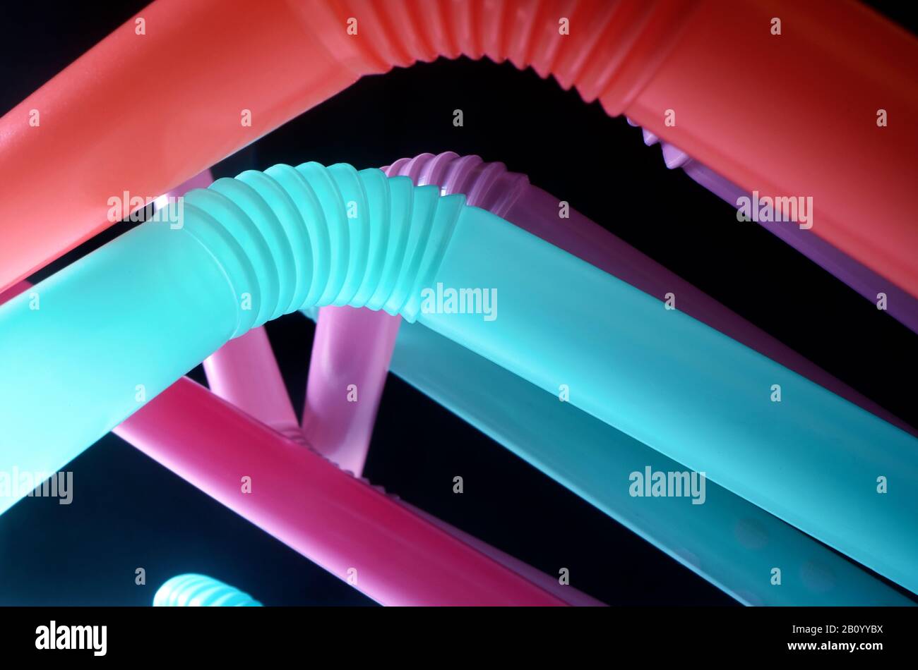 Background from multi-colored plastic cocktail tubes on a dark background Stock Photo