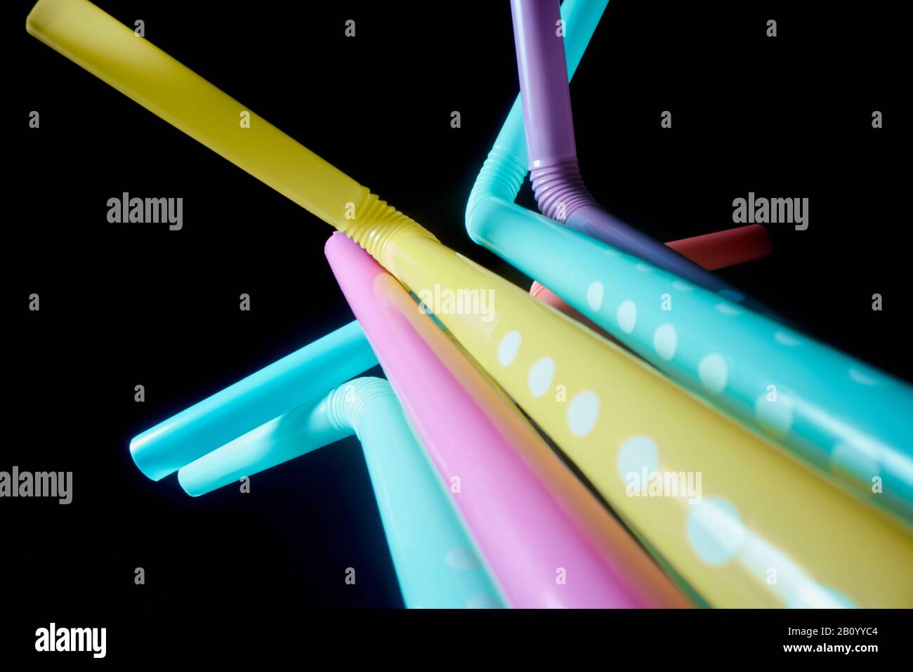 Background from multi-colored plastic cocktail tubes on a dark background Stock Photo