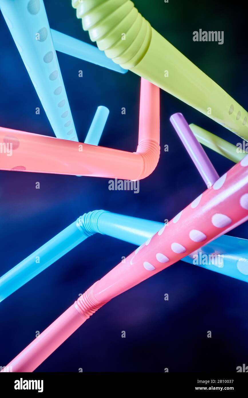 Background from multi-colored plastic cocktail tubes on a dark background Stock Photo